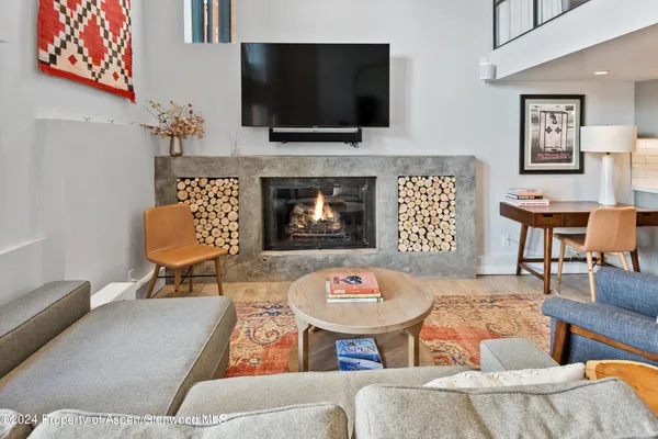 a living room with furniture a flat screen tv and kitchen view