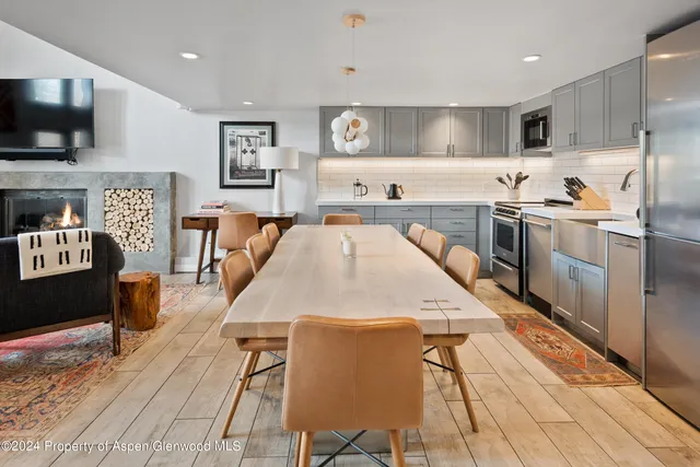 a kitchen with stainless steel appliances kitchen island granite countertop a table chairs microwave and sink