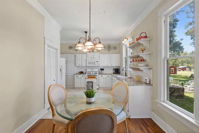 a dining room with furniture a chandelier and wooden floor