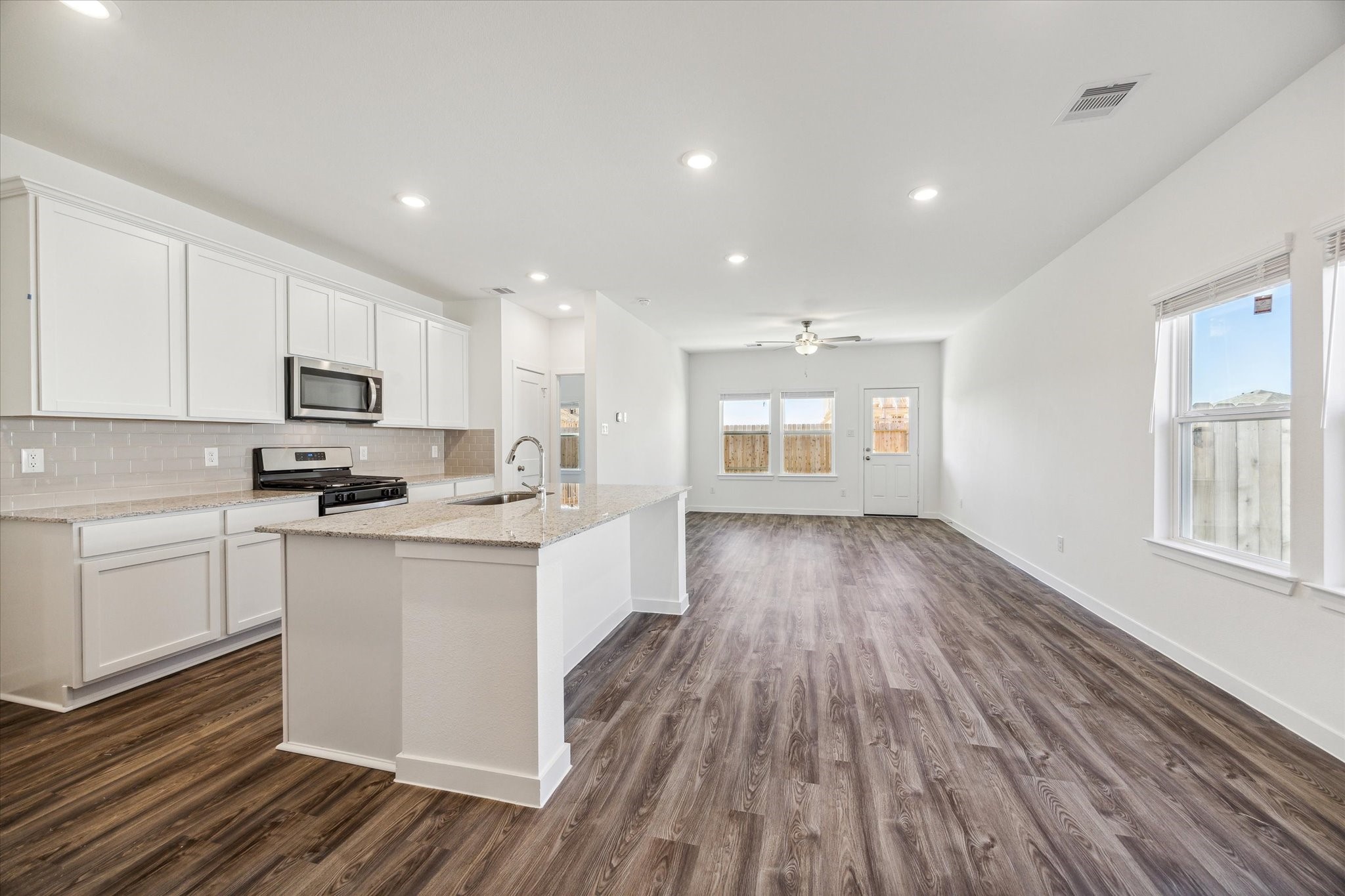 3926 Glory Grn Drive Brookshire, TX 77423 - Photo 5 of 21 a kitchen with wooden floors and white cabinets