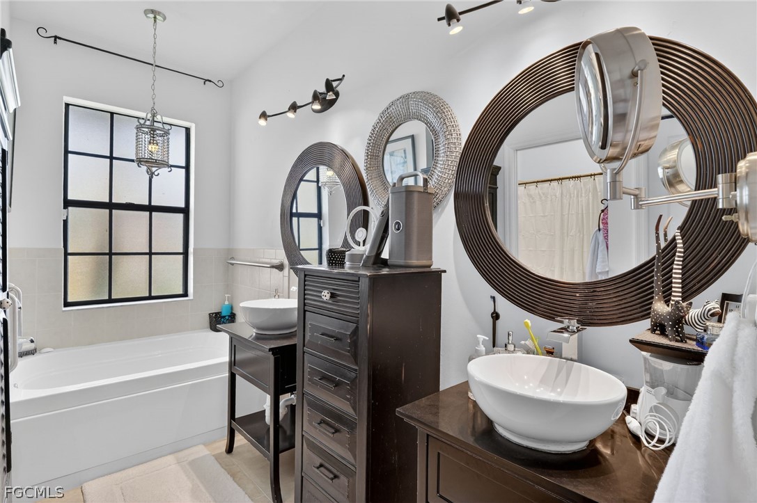 4914 Southwest 25th Court Cape Coral, FL 33914 - Photo 13 of 22 a bathroom with a sink a mirror and a bathtub