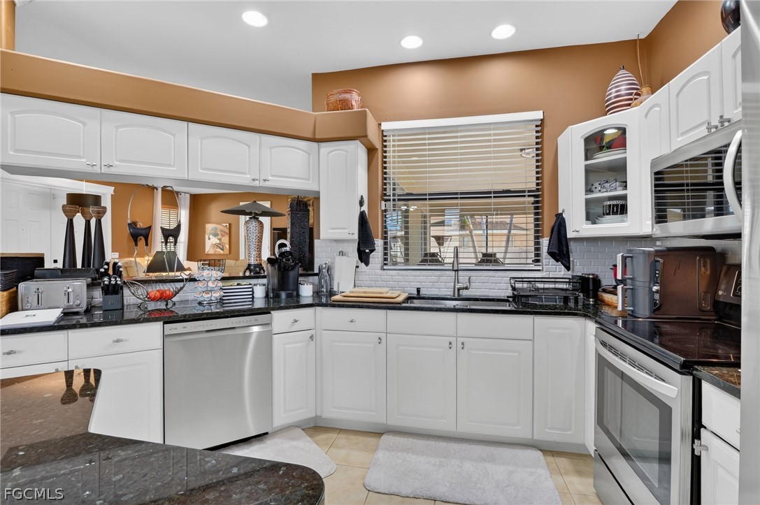 4914 Southwest 25th Court Cape Coral, FL 33914 - Photo 6 of 22 a kitchen with stainless steel appliances granite countertop a sink and cabinets