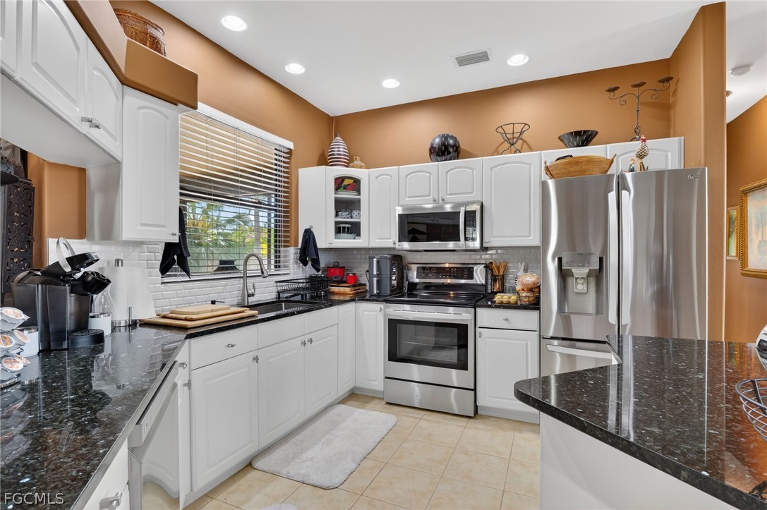 4914 Southwest 25th Court Cape Coral, FL 33914 - Photo 8 of 22 a kitchen with white cabinets and stainless steel appliances
