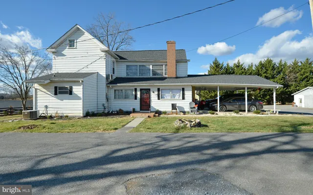 a view of road and car parked in front of house