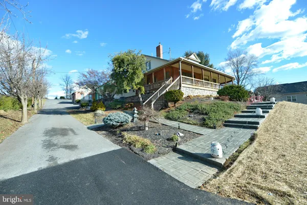 a front view of a house with garden and parking