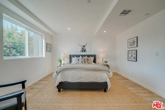 a spacious bedroom with a bed and a window