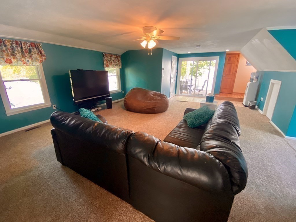 10 Cedar Lane Tyngsborough, MA 01879 - Photo 31 of 42 a living room with furniture a flat screen tv and a fireplace