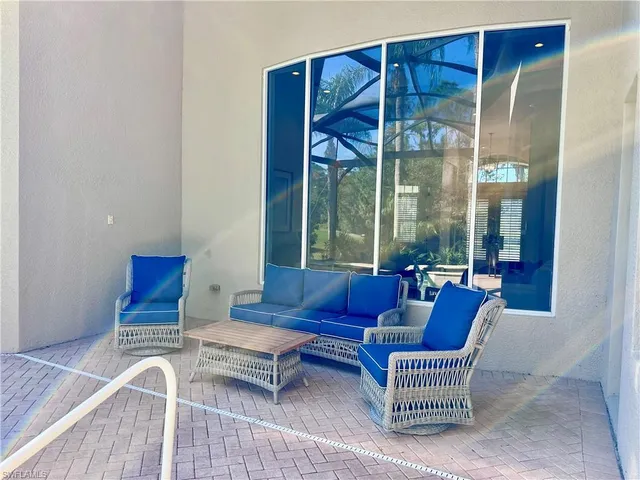 a living room with furniture a rug and a large window