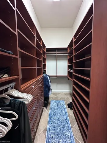 a view of walk in closet and wooden wooden floor
