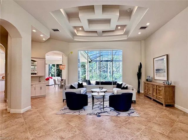 a living room with furniture a flat screen tv and large windows