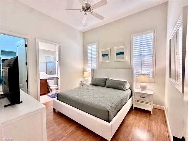 a bedroom with a bed and a flat tv screen on dresser