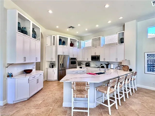 a kitchen with a dining table chairs and refrigerator