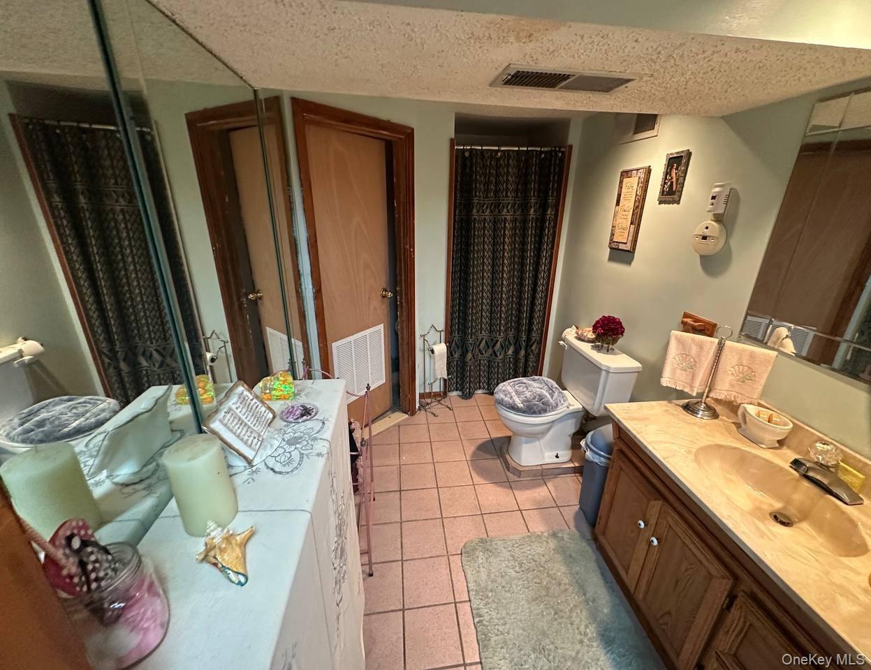 191-53 115th Road Queens, NY 11412 - Photo 14 of 16 a bathroom with a sink mirror and toilet