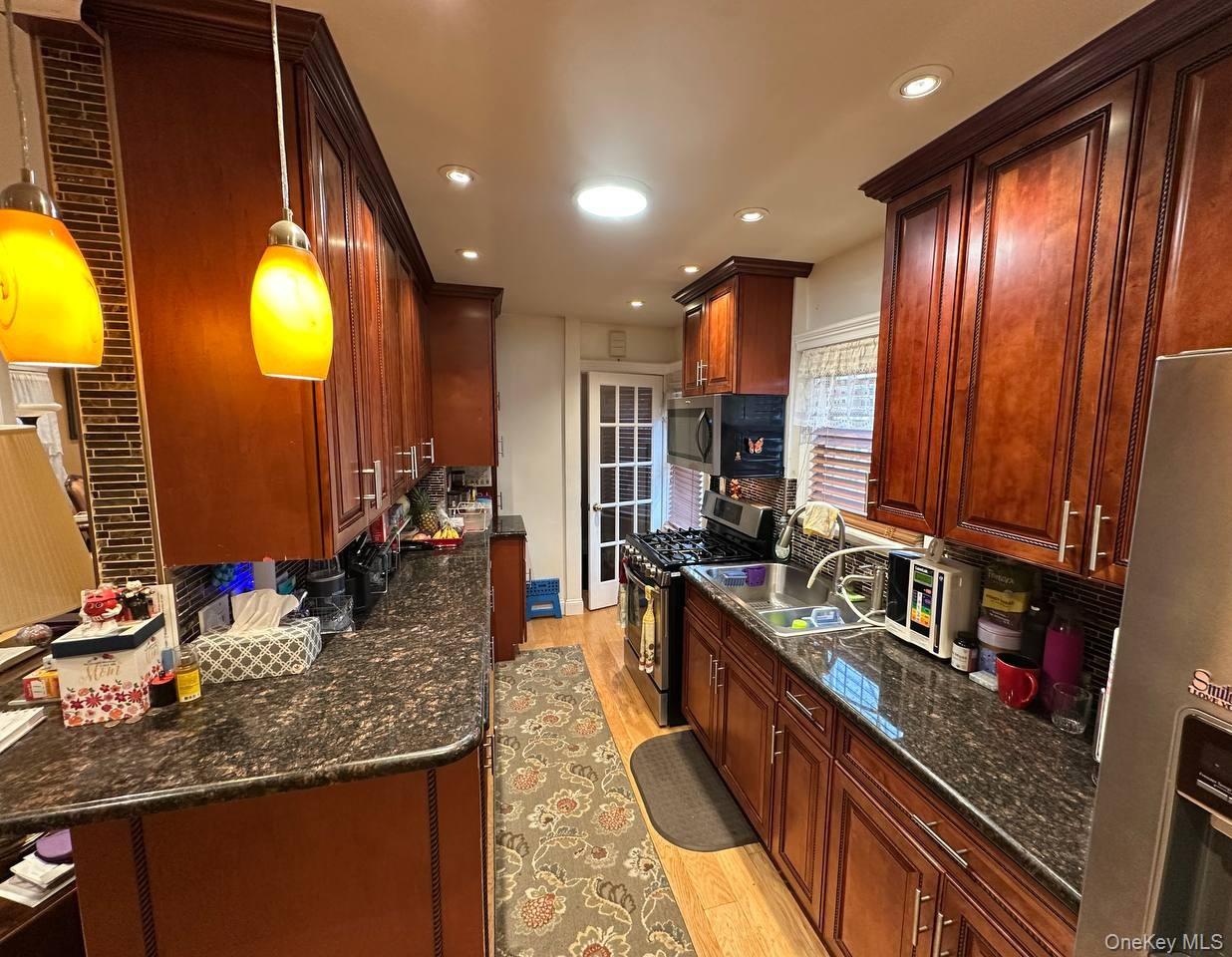 191-53 115th Road Queens, NY 11412 - Photo 5 of 16 a kitchen with stainless steel appliances granite countertop sink stove and cabinets
