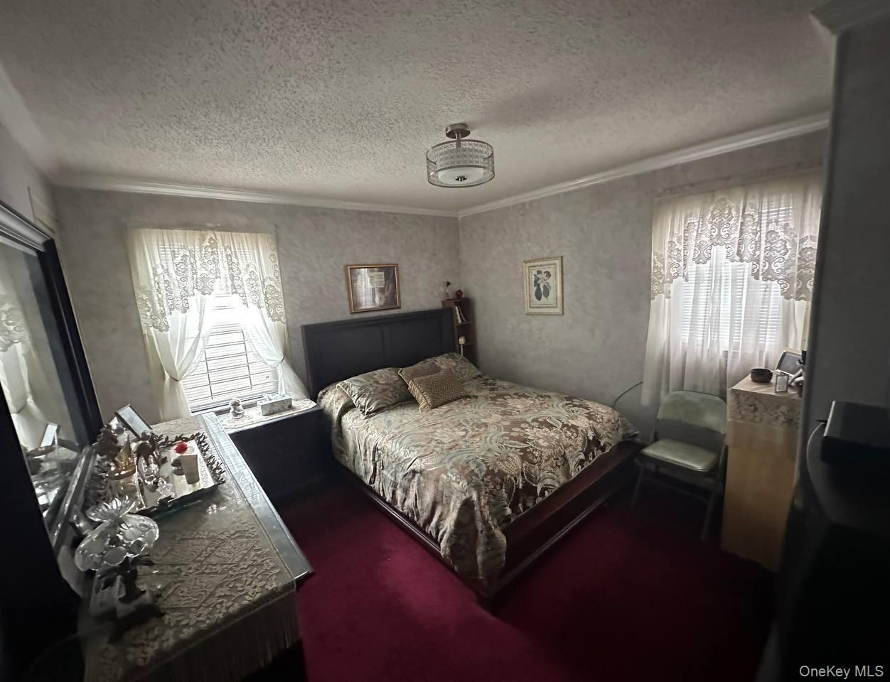 191-53 115th Road Queens, NY 11412 - Photo 7 of 16 a bedroom with a bed dresser mirror and a window