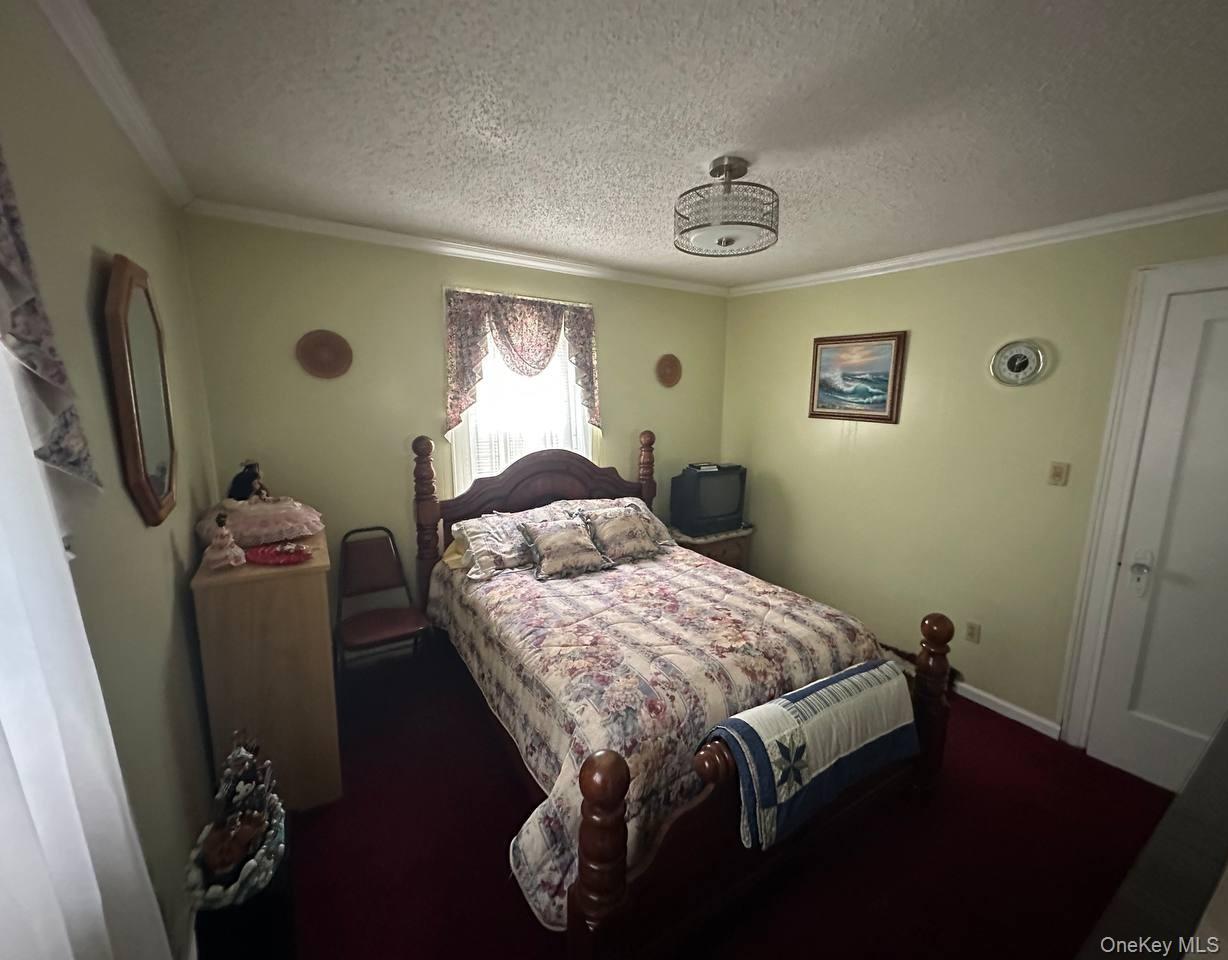 191-53 115th Road Queens, NY 11412 - Photo 8 of 16 a bedroom with a bed and a chandelier