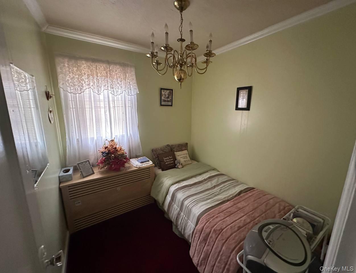 191-53 115th Road Queens, NY 11412 - Photo 9 of 16 a bedroom with a bed and a chandelier