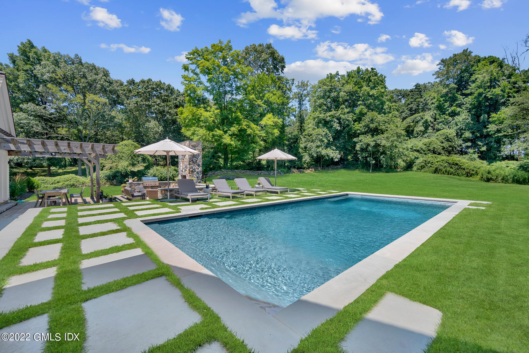 269 Riversville Road Greenwich, CT 06831 - Photo 41 of 55 a view of a swimming pool with a patio and a garden