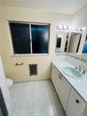 a bathroom with a sink a large mirror and a toilet