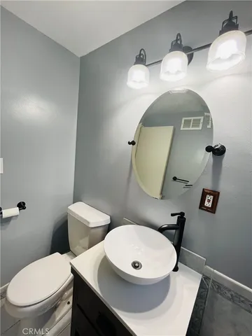 a bathroom with a toilet a sink and mirror