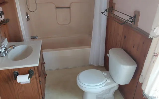 a white toilet sitting next to a bath tub