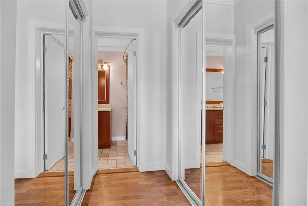a view of a hallway with wooden floor and glass door