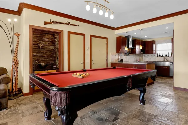 a room with pool table and windows