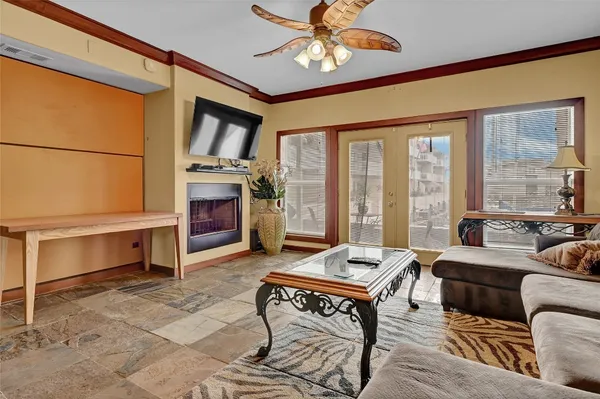 a living room with furniture a fireplace and a floor to ceiling window