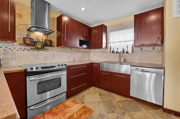 a kitchen with stainless steel appliances granite countertop a stove a sink and a microwave