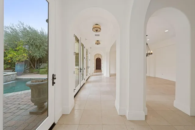 a view of a hallway with wooden floor and windows