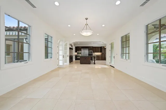 an empty room with windows and fireplace