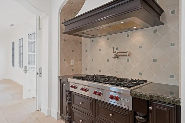 a living room with stainless steel appliances kitchen island granite countertop a refrigerator and cabinets