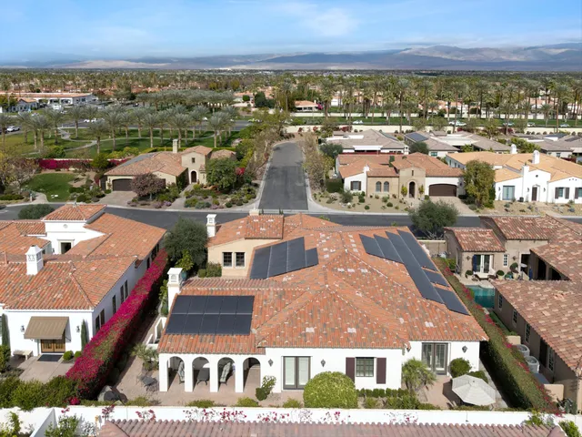 an aerial view of a house with a mountain