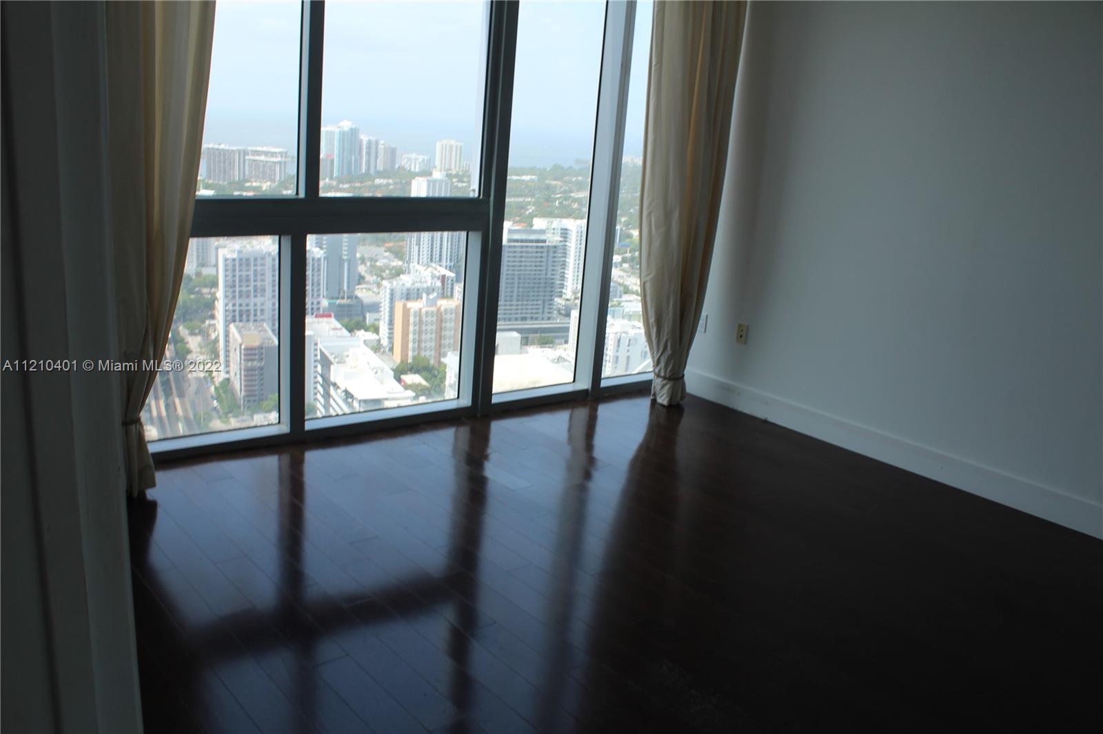 92 Southwest 3rd Street, Unit 5204 Miami, FL 33130 - Photo 17 of 20 a view of an empty room with wooden floor and a window