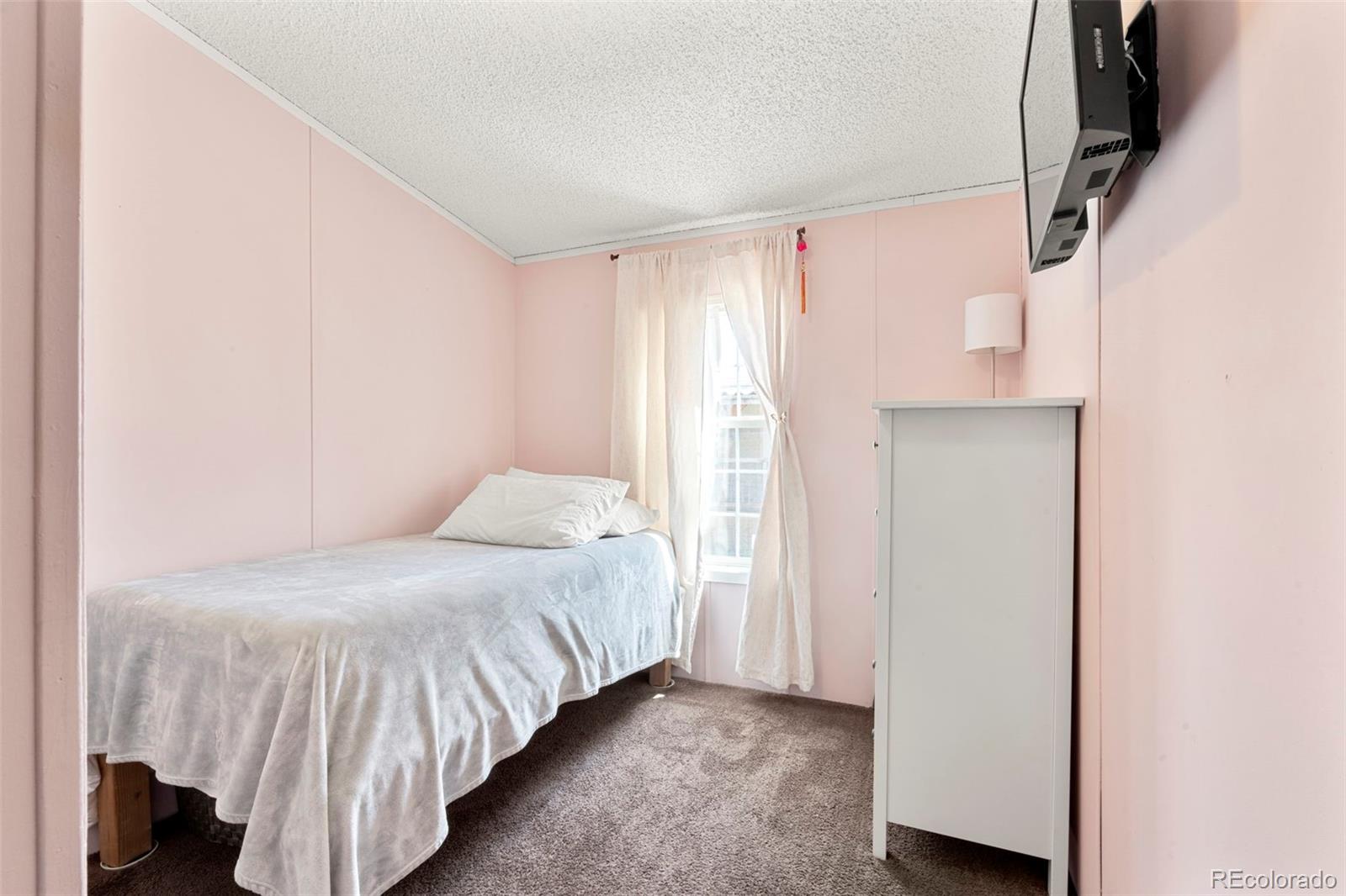 9850 Federal Boulevard Denver, CO 80260 - Photo 12 of 17 a bedroom with a bed and a window
