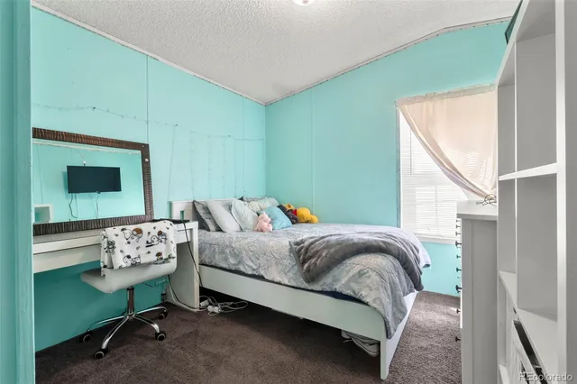 a bedroom with a bed wooden floor and window