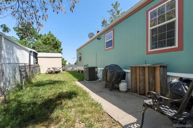 a backyard of a house with barbeque oven and glass top table and chairs