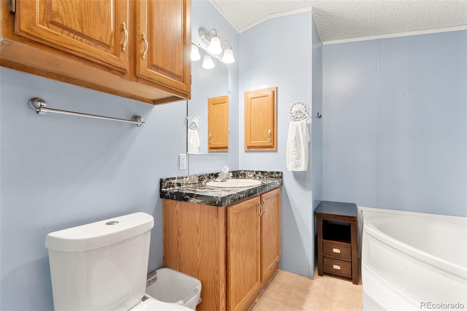 9850 Federal Boulevard Denver, CO 80260 - Photo 4 of 17 a bathroom with a granite countertop sink and a bathtub