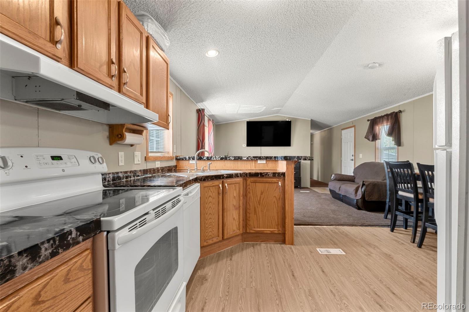 9850 Federal Boulevard Denver, CO 80260 - Photo 7 of 17 a kitchen with stainless steel appliances kitchen island granite countertop a stove and a sink