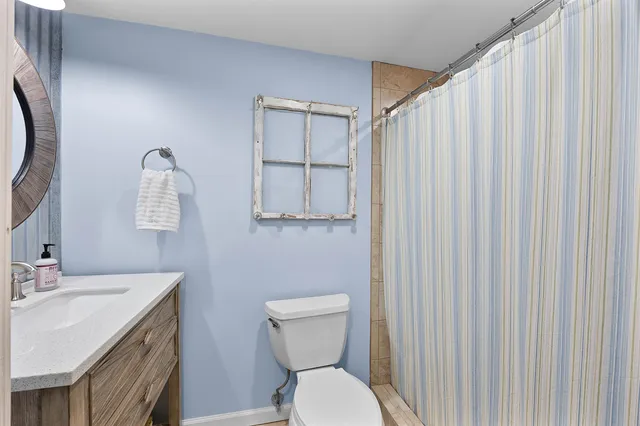 a bathroom with a toilet a sink and mirror