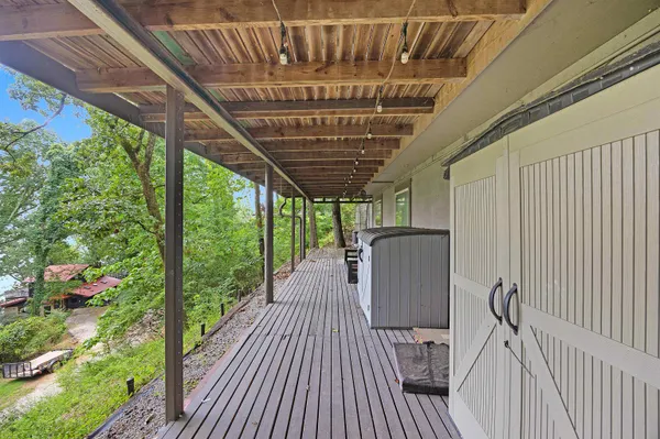 a view of a porch with wooden floor chairs and iron stairs