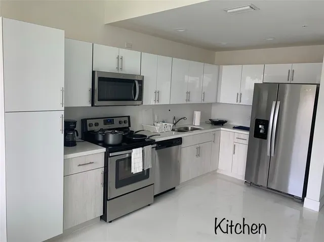 a kitchen with a sink a stove a refrigerator and cabinets