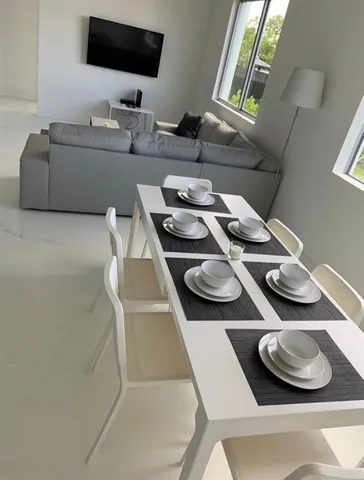 a dining room with furniture and a flat screen tv