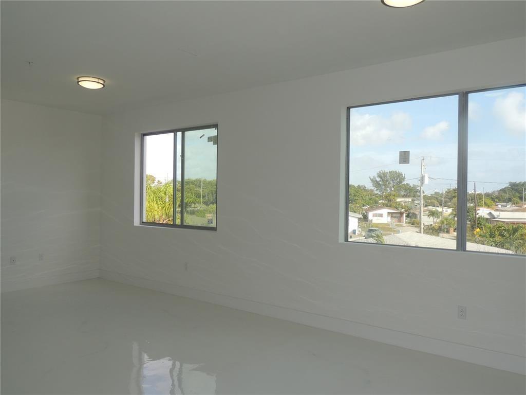 520 Foster Road, Unit 101 Hallandale Beach, FL 33009 - Photo 4 of 8 an empty room with a window