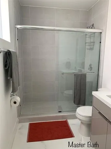 a bathroom with a shower a toilet and a sink
