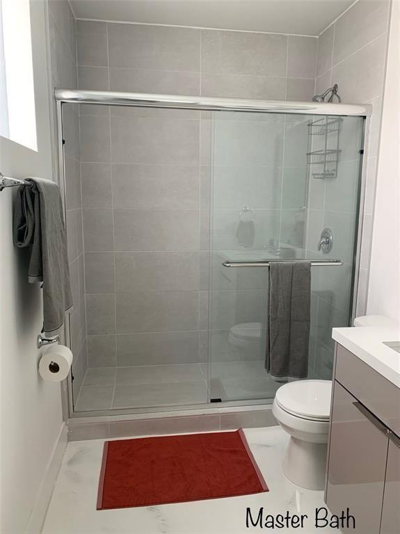520 Foster Road, Unit 101 Hallandale Beach, FL 33009 - Photo 6 of 8 a bathroom with a shower a toilet and a sink