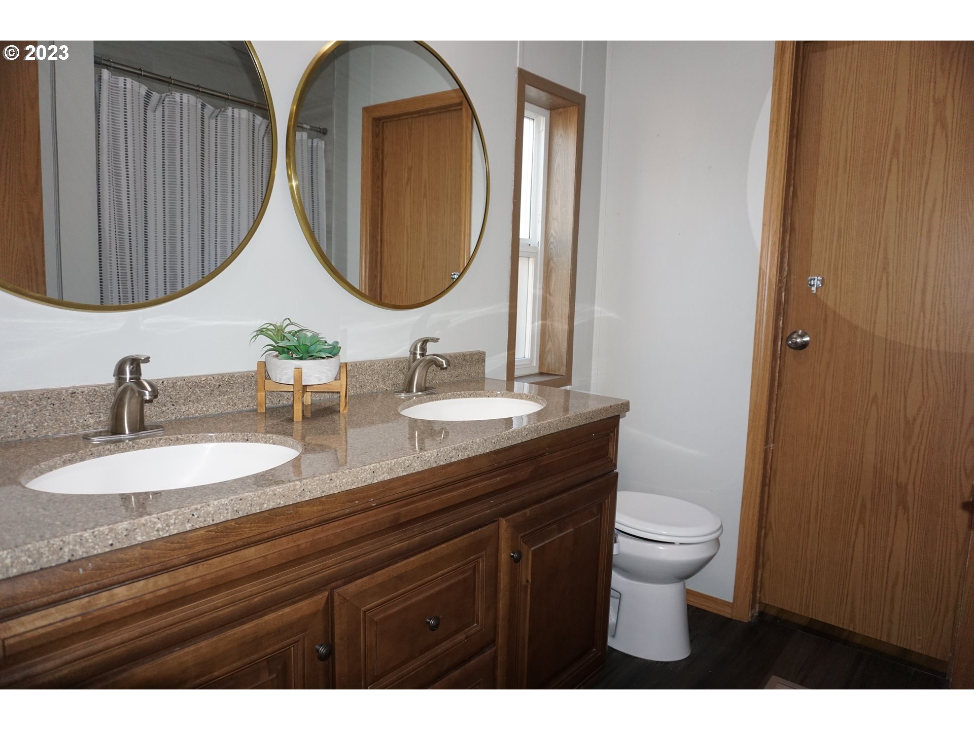 1949 Southeast Palmquist Road Gresham, OR 97080 - Photo 19 of 31 a bathroom with a granite countertop toilet a sink and a mirror