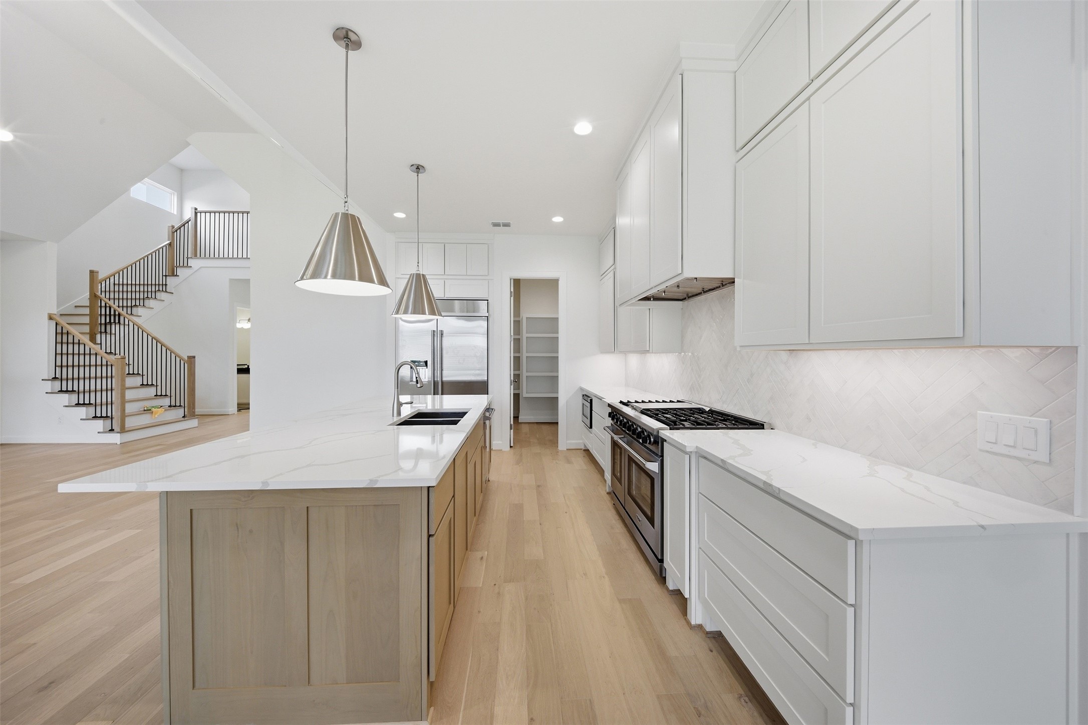 416 Venado View Court Conroe, TX 77304 - Photo 7 of 34 Beautifully appointed chef’s kitchen with custom cabinetry, oversized waterfall island, luxury appliances, designer lighting, and seamless open-concept flow.