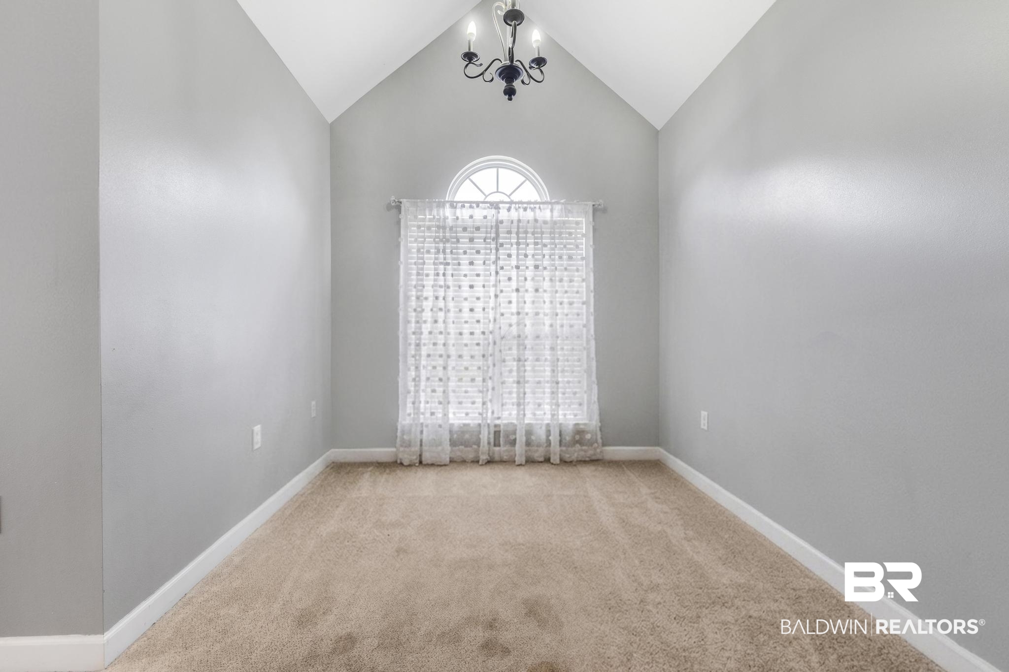35814 Delvan Lane Bay Minette, AL 36507 - Photo 40 of 53 Vaulted ceiling room featuring light gray walls, plush carpeting, and a prominent arched window