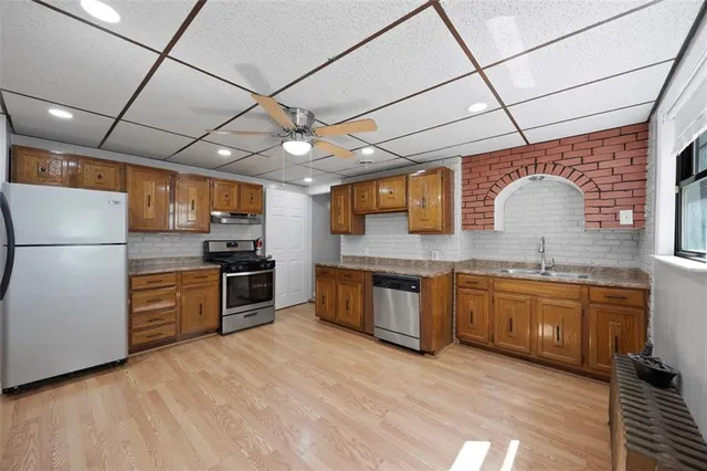 a kitchen with granite countertop stainless steel appliances and wooden cabinets